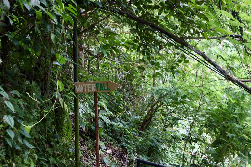 sign along the way to tukad cepung waterfall that says "waterfall" and pointing in the direction of the correct path to tukad cepung.